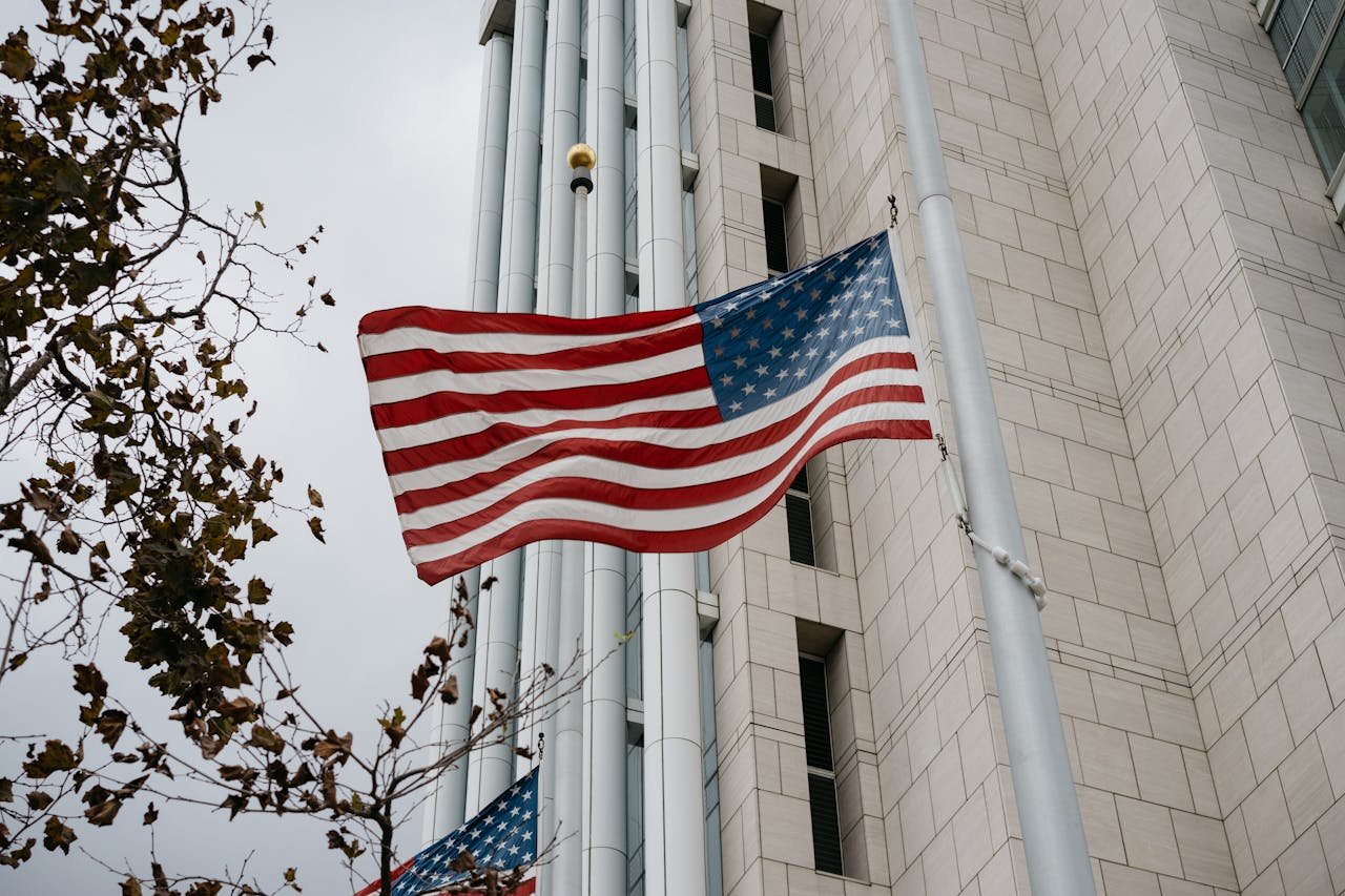 our-story Low angle of American flag waving in front of a government building in Anaheim, CA.